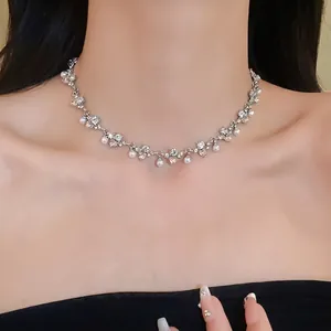 Elegant silver-toned rhinestone heart and pearl choker necklace worn by a model
