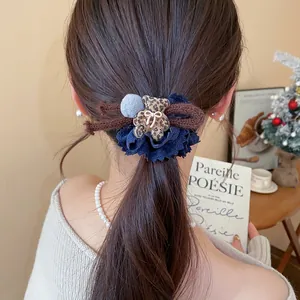 Close-up detail of autumn winter hair tie with leopard print bear and blue lace