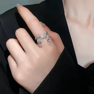 Detalle de un anillo abierto plateado con borlas colgantes de circonita marquesa