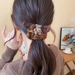 Detailed view of leopard print bear scrunchie with elegant brown fabric ruffles on hair