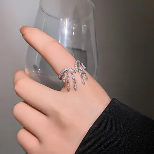Anillo abierto elegante con borlas de circonita con diseño lujoso y minimalista en el dedo