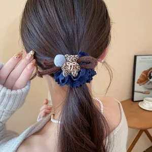 Close-up of leopard print bear hair tie with blue lace details on brown hair
