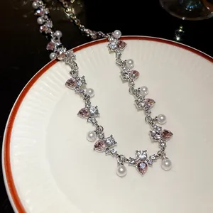 Detail view of irregular heart-shaped necklace with pink rhinestones and pearls