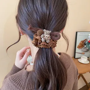 Close-up of brown lace hair scrunchie featuring a cute leopard print flocked bear charm