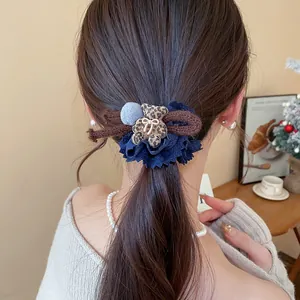 Close-up view of a sweet blue fabric lace hair tie with a leopard print flocked bear