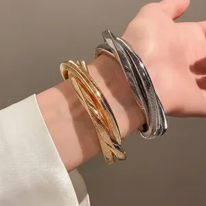 Minimalist punk style intertwined metal swirl bracelet in gold and silver finish