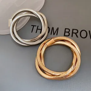 Set of punk style gold and silver spiral textured metal wrap bracelets for modern women