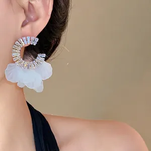 Orecchini a cerchio in zircone con petali di fiori bianchi traslucidi su modella asiatica