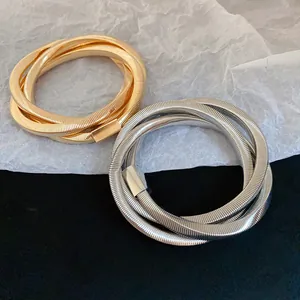 Detail view of metallic coiled punk bracelets in gold and silver finish