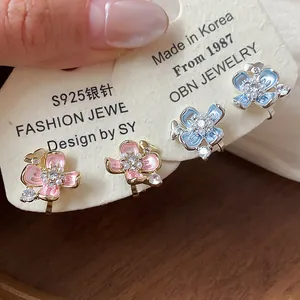 Close-up of 18k gold plated flower ear clips with pearls and crystals for non-pierced ears.