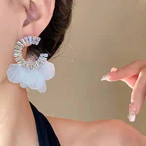Primo piano dettagliato di eleganti orecchini a cerchio in zircone con petali bianchi