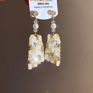 Primo piano di eleganti orecchini a pendente vintage con perle e pietre di cristallo.