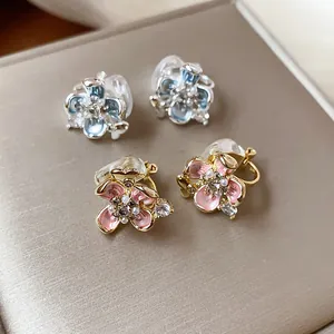 Detailed view of delicate flower-shaped clip-on earrings with pearl and crystal accents