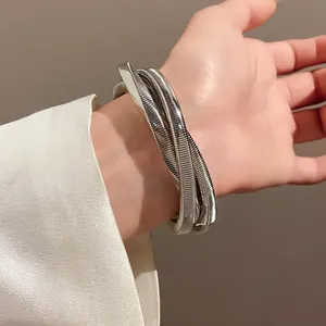 Macro view of the silver metallic coiled bracelet with an irregular vortex design.
