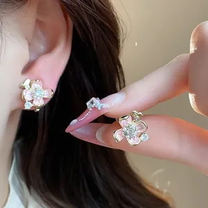 Detailed view of 18k gold plated flower ear clips with pink enamel and pearls