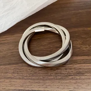 Detailed close-up showing the metallic texture and clasp of a silver coiled spiral bracelet
