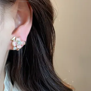 Detailed macro shot of sweet pink enamel flower earring with gold plating and pearls