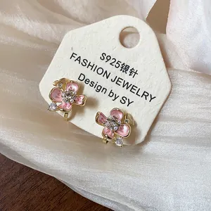 Detailed view of 18k gold-plated pink flower clip-on earrings with pearl accents