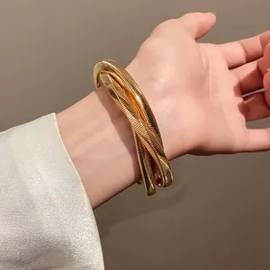 Close-up of bold gold-colored coiled spiral metal bracelet in minimalist punk style