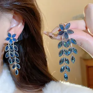 Elegant blue glass flower and wheat leaf tassel earrings with silver needle detail.