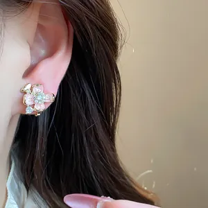 Elegant pink enamel flower clip-on earrings with gold plating and sparkling crystals.