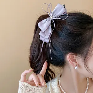 Detailed close-up showing elegant lavender satin bow banana hair clip on model hair