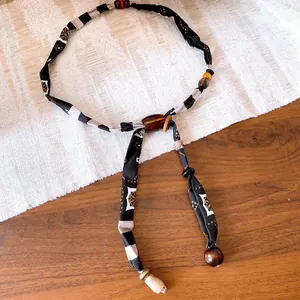 Vue détaillée d'un collier écharpe en tissu bohème avec perles d'ambre et accents en bois