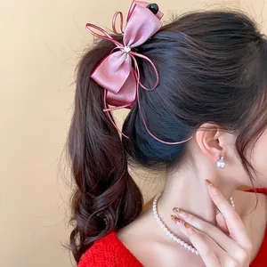 Elegant pink chiffon bow banana hair clip detail on a ponytail hairstyle