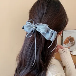 Elegant close-up of a silver chiffon bow hair clip with a star rhinestone detail.