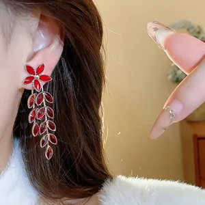 Close-up of elegant red flower tassel earrings with leaf-shaped gemstones