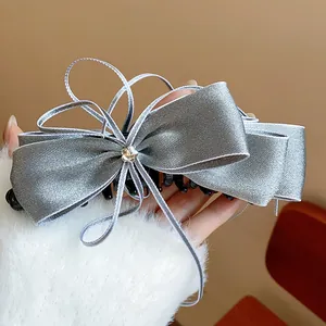 Detail of elegant grey ribbon bow banana hair clip with a sparkling rhinestone star