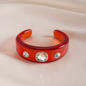 Elegante brazalete vintage de resina roja con tres brillantes diamantes de imitación