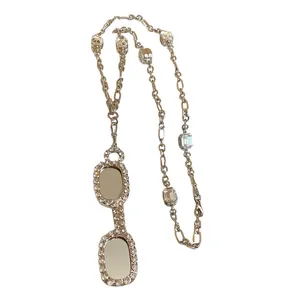 Stylish silver necklace featuring zircon-encrusted glasses pendant and square stones.