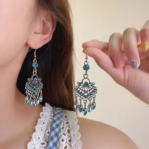Detailed view of vintage bohemian chandelier earrings with blue stones on a model