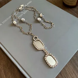 High-quality detail view of silver-toned necklace with sparkling glasses-shaped pendant