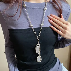 Elegant silver-tone long chain necklace with a stylish zircon-studded glasses pendant