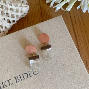 Close-up detail of vintage wooden round drop earrings with clear acrylic pendants