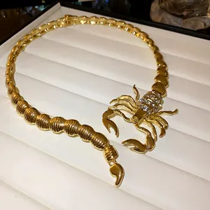 Macro detail view of a gold scorpion necklace with sparkling rhinestone accents