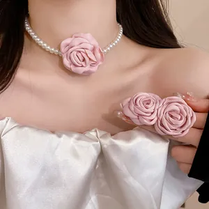 Close-up detail showing the elegant pink fabric rose and white pearl choker necklace set