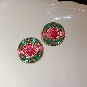 Primo piano di orecchini vintage in stile palazzo con cristalli rosa e verdi