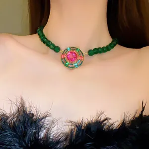 Dettaglio di una collana vintage stile corte con perline verdi e cristallo rosa