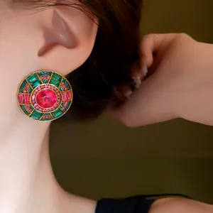 Dettaglio di orecchini rotondi in stile palazzo vintage con strass colorati sulla modella