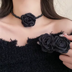 Close-up detail of a French style black fabric rose choker and matching floral hair clip
