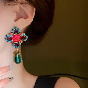 Primo piano di orecchini a fiore vintage in stile palazzo con gocce di cristallo colorate