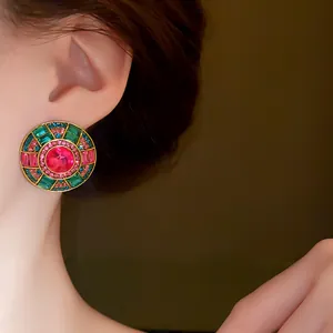 Dettaglio macro di orecchini tondi in stile vintage con cristalli rosa e verdi
