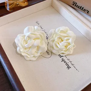 Close-up view of elegant cream white fabric rose handmade floral jewelry accessory detail