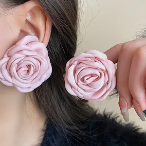 Close-up of elegant pink fabric rose flower earrings for a sweet French style