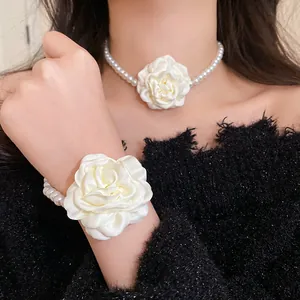 Detail of white fabric rose flower and pearl choker necklace with matching bracelet
