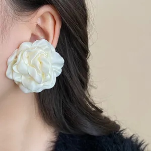 Detailed macro view of the textured fabric petals on the white rose flower earring