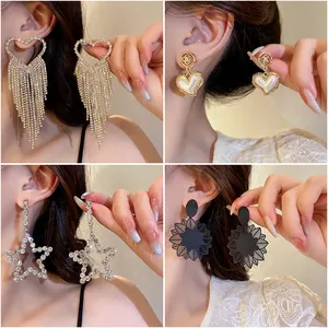 Vue détaillée de boucles d'oreilles cœur à pompons et étoiles serties de diamants